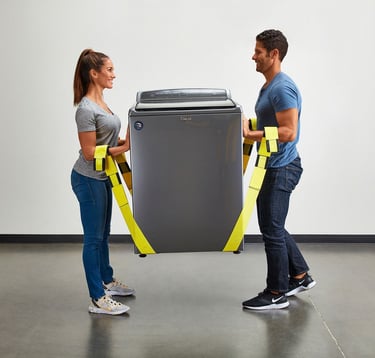 a man and woman from an appliance removal service holding a large washer 