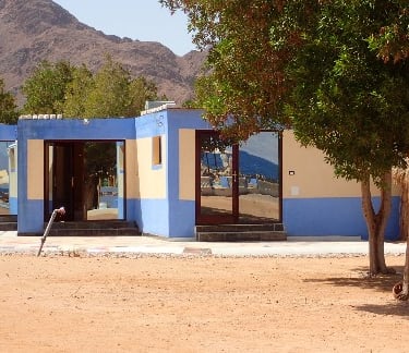 Our studio blue building with a mountain in the background