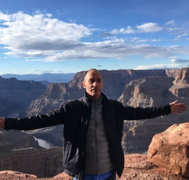 a man standing on a cliff overlooking a canyon