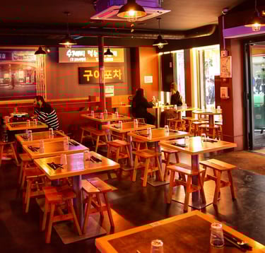 a restaurant with tables and chairs and people sitting at tables