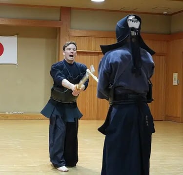 a man in a black suit and a woman in a black Kendo outfit