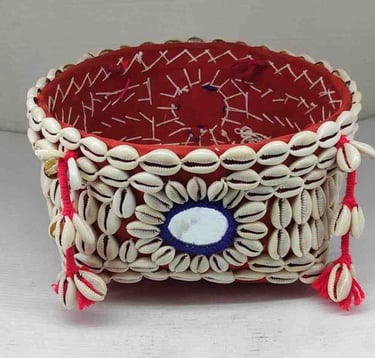 "Decorative bamboo basket wrapped in red fabric with shell embellishments and floral garland–Meant for export"