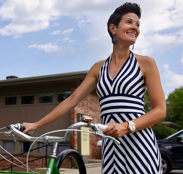 Woman in striped dress standing with bike