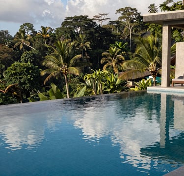 A stunning infinity pool overlooking a tropical rainforest in a South American luxury eco-resort. Clear water reflecting the sky, modern architecture, peaceful and aspirational mood. Clean lines, navy blue and light grey color palette.