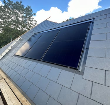 Black solar panels installed on a grey slate roof for residential renewable energy in Milton Keynes.