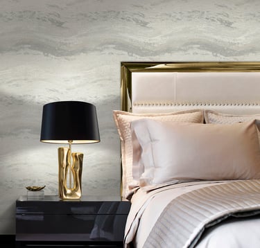 Elegant bedroom with marble textured wallpaper, gold table lamp, and luxury bedding.