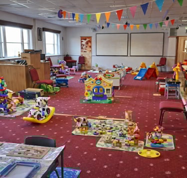 Play area inside New Life Church baby & toddler group in Saffron Walden with toys, soft play, slides and seating for parents.