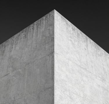 A high-contrast black and white photograph of a sharp, concrete architectural corner against a dark sky. Minimalist and precise composition. North American business aesthetic.