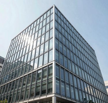 A minimalist, low-angle photograph of striking modern corporate architecture featuring glass and steel. Bright daylight, clear sky. Reflected light in light blue and soft grey tones. Global / Emerging Markets.
