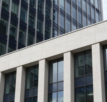 A close-up, sharp photography of architectural details of a modern bank headquarters in an emerging market financial district. The facade is composed of glass and steel in shades of dark navy and off-white. The lighting is clean and professional, conveying reliability and modern strength.