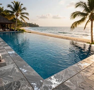 A high-end luxury resort infinity pool overlooking a tropical beach in South Asia. The scene features deep navy blue water and silver gray stone tiling. The lighting is golden hour, warm and inviting.