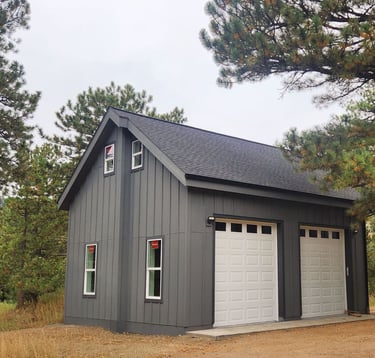 Side profile of a custom mountain garage with dark vertical siding.