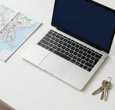 A top-down, clean workspace shot featuring a high-end laptop, a minimalist travel map, and a set of keys on a polished white desk. The aesthetic is extremely organized and professional, using a palette of white, deep navy (#1E2B38), and silver.