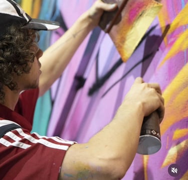 un homme avec une casquette entrain de peindre un graff