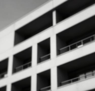 Dramatic black and white photography of a modern architectural structure with sharp lines and strong shadows, representing solidity and masculine strength.