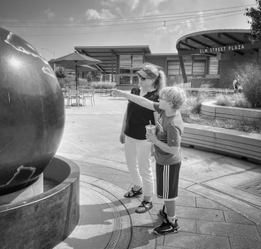 Photo of young boy and his mother looking at a Kugel Ball