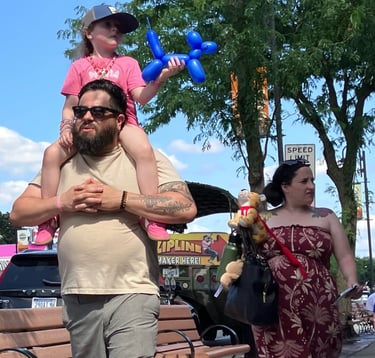 Boy riding on Dad’s shoulder walking down Broadway in Wisconsin Dells
