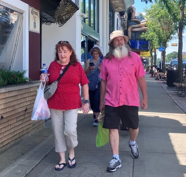 Man with white beard walking down Broadway Street