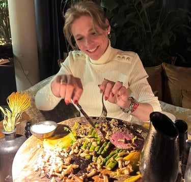 een lachende vrouw die een stuk vlees snijdt