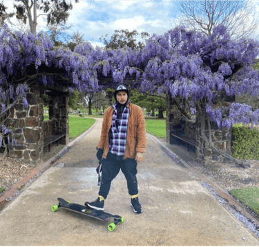 Kasaysayan DTC First Writer Match Makata Cassidy holding a skateboard, park, font of wisterias 