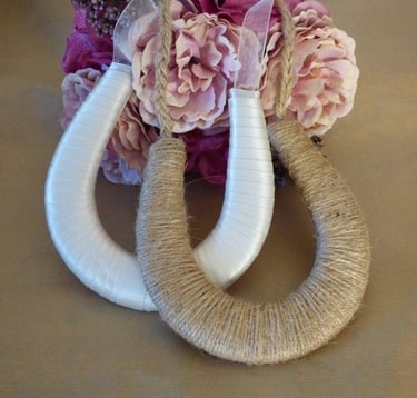 a bouquet of flowers and a our ribbon and twine horseshoes