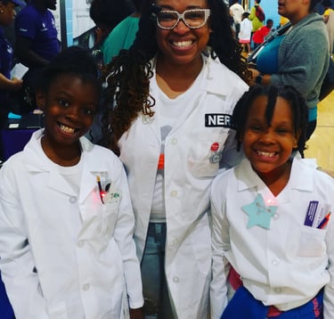 Shenell poses with two young scholars. All three are in labcoats