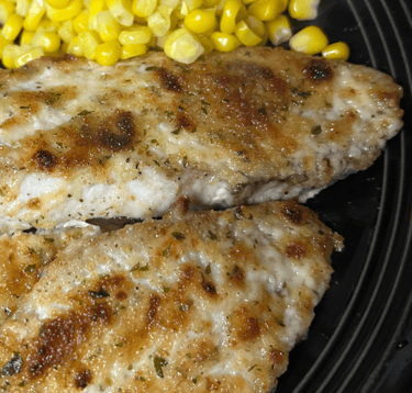 Broiled talapia on a plate with corn.