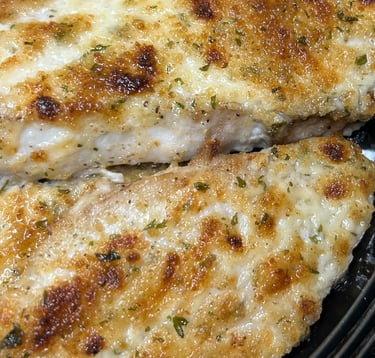 Broiled talapia with breading ready to eat on a plate.