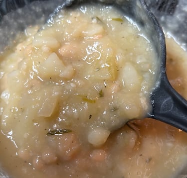 Potato Soup, when copleted, with large serving spoon starting to lift out of dish. For FlavorfulBites