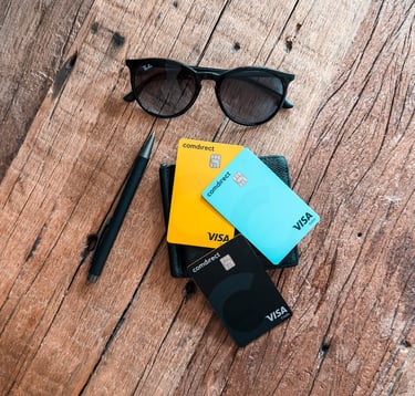 credit cards, sunglasses, wallet, pen on a wooden table
