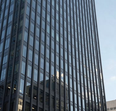A sharp, professional photograph of a modern glass skyscraper's facade in a North American city. The lighting is bright day, emphasizing the clean architectural lines and Slate Gray tones of the structure against a clear sky.