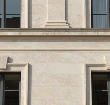 Abstract and elegant architectural detail of a private mansion's limestone facade. Clean lines, minimalist composition, soft European sunlight, conveying a sense of exclusivity and off-market privacy.