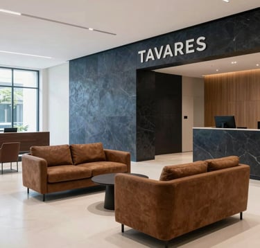 A sophisticated interior shot of the Instituto Tavares lobby. Minimalist decor with umber brown furniture, dark slate blue architectural details, and soft off-white flooring. The space exudes tranquility, professionalism, and high-end European elegance.