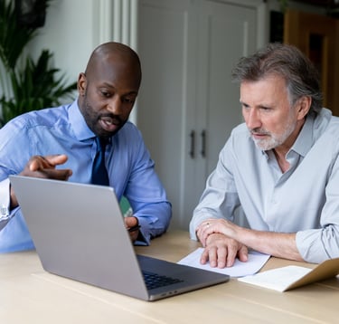 two men sitting at a table with papers and papers