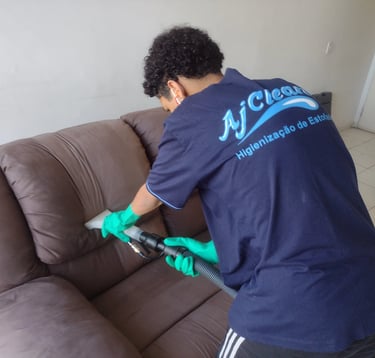 Equipe AJ Clean usando extratora para remover manchas e odores do estofado marrom.