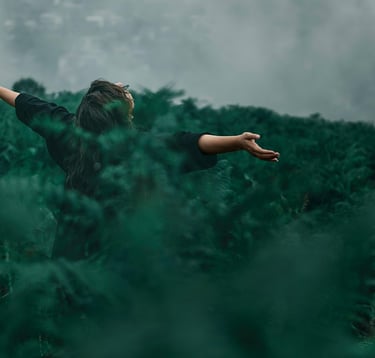 a woman standing in a field with her arms outstretched out