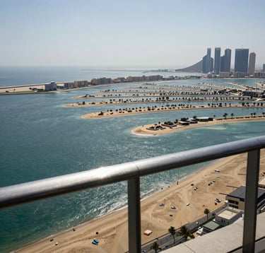 The view from a luxury penthouse balcony in a Middle Eastern / Gulf city, looking out over the sparkling Arabian Gulf and the Palm Jumeirah. The lighting is bright and crisp, showcasing the deep blue water and gold sands of the coastline.