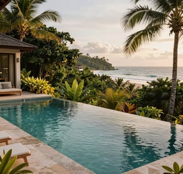 A luxury infinity pool of a private villa overlooking the ocean in a Central American / Costa Rican coastal town, deep forest green tropical plants surrounding the deck, clear soft sage water reflections, serene afternoon lighting.