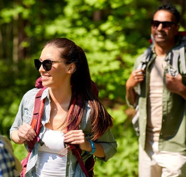 People hiking in the woods and wearing a sunglasses
