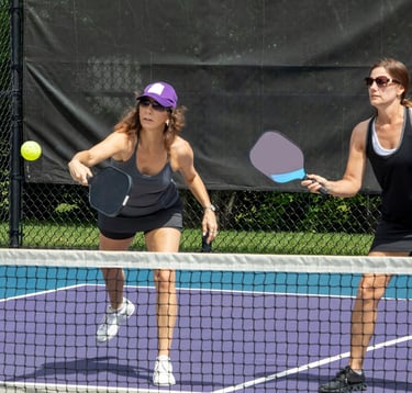 Two ladies playing pickleball