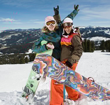 Two friends snowboarding and wearing eye protection