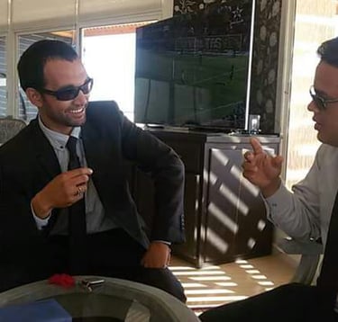 Casal gay brasileiro no Deserto do Saara, pôr do sol com camelos, viagem romântica Marrocos.