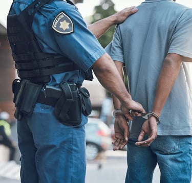 A police officer putting handcuffs on a arrested man