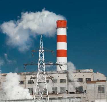 Smoke comming out of a red and white striped factory chimney