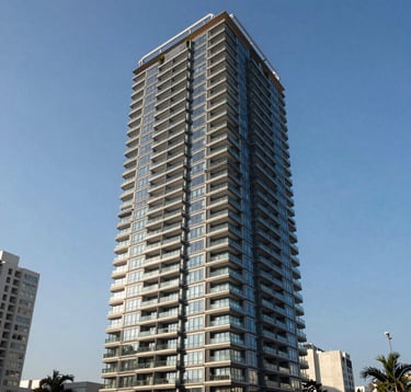 A professional architectural photograph of a high-rise luxury apartment building in a major Latin American business district. The shot is taken during the day under a clear blue sky, showing a sophisticated glass and steel structure with elegant balcony landscaping.