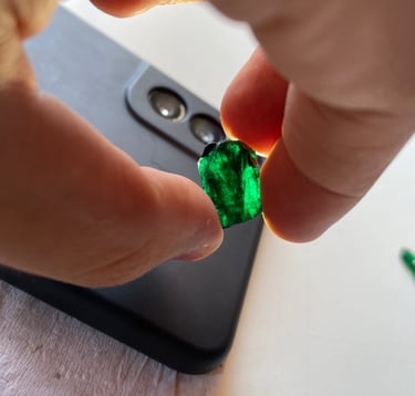 a person holding a green emerald in their hand