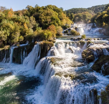 Waterfalls cascading through lush vegetation in Krka National Park.