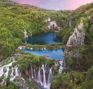 Wooden walkways leading through turquoise lakes and waterfalls in Plitvice Lakes National Park.