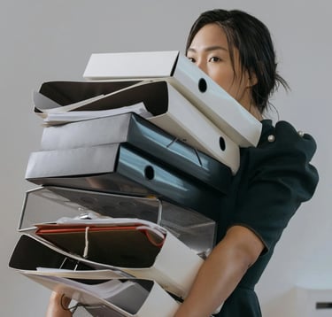 Mujer cargando folios y carpetas con documentos de aduana.