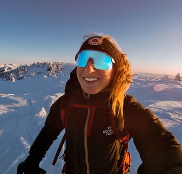 Mack Audino standing on a mountaintop, overlooking expansive landscapes, highlighting adventure trav